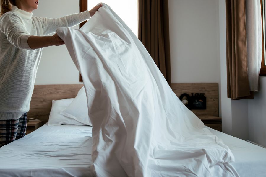 mujer colocando bien las sábanas